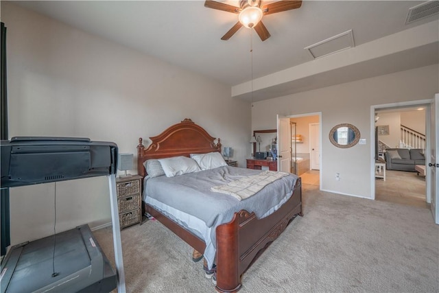 carpeted bedroom with ensuite bath and ceiling fan