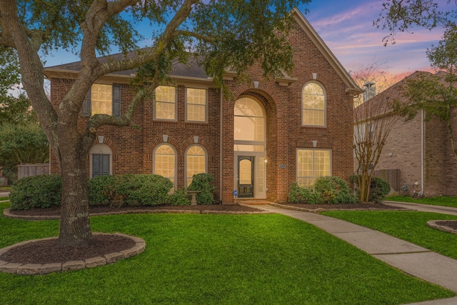 view of front of home with brick siding and a front yard