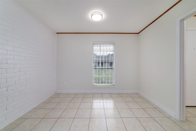 tiled empty room featuring ornamental molding and brick wall