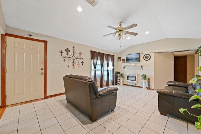 tiled living room with heating unit, vaulted ceiling, and ceiling fan