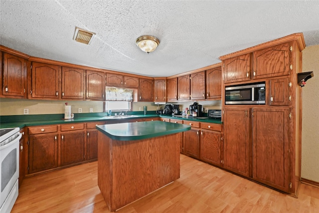 kitchen featuring white range with electric cooktop, sink, light hardwood / wood-style flooring, and a kitchen island