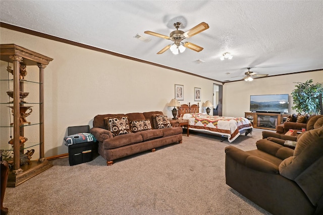 bedroom with ceiling fan, ornamental molding, carpet floors, and a textured ceiling