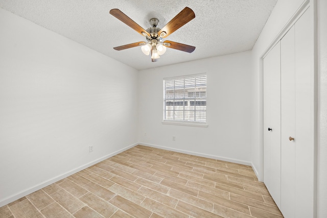 unfurnished bedroom with ceiling fan, a textured ceiling, a closet, and light wood-type flooring