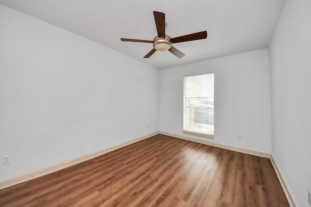 spare room featuring dark wood-type flooring and ceiling fan