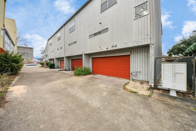 exterior space featuring a garage and mail boxes