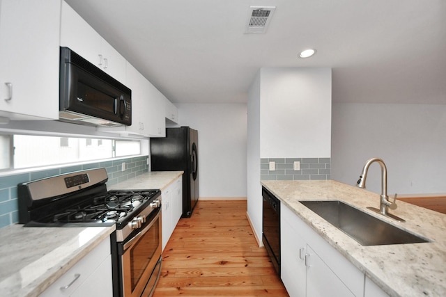 kitchen featuring sink, white cabinetry, light hardwood / wood-style flooring, light stone countertops, and black appliances