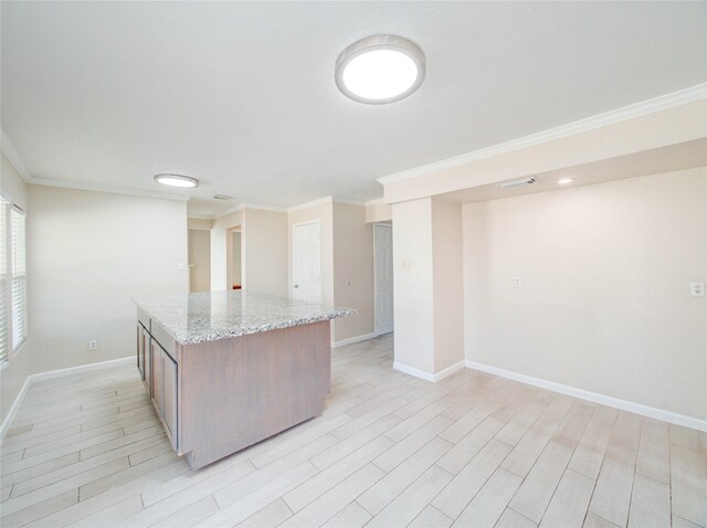 kitchen with light stone counters, light hardwood / wood-style flooring, and ornamental molding