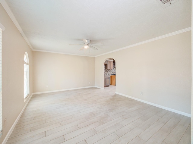 spare room with crown molding, ceiling fan, and light wood-type flooring