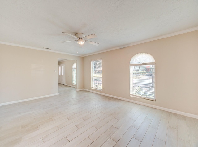 spare room featuring crown molding, a textured ceiling, and light hardwood / wood-style floors