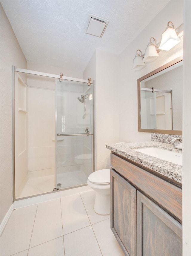 bathroom with vanity, toilet, tile patterned floors, and walk in shower