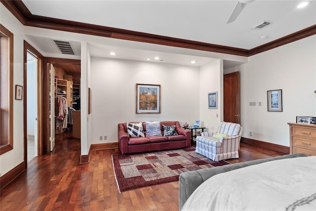 bedroom with crown molding, a walk in closet, ceiling fan, and dark hardwood / wood-style flooring