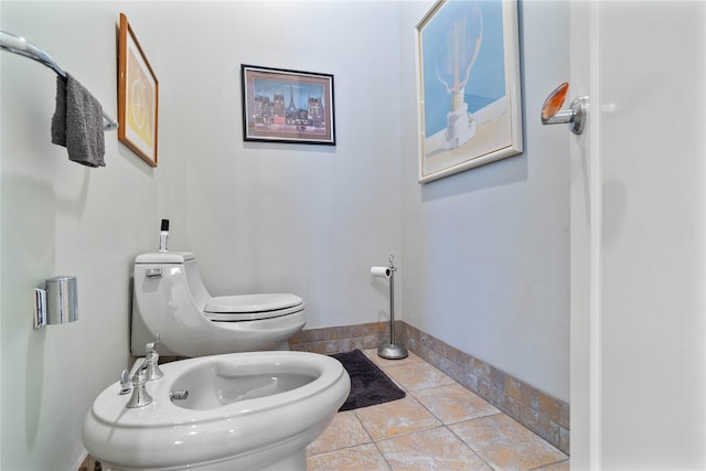 bathroom with a bidet, tile patterned flooring, and toilet