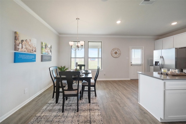 dining space with crown molding, a chandelier, and dark hardwood / wood-style flooring