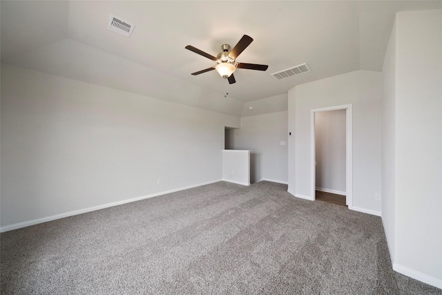 unfurnished bedroom featuring dark colored carpet, vaulted ceiling, and ceiling fan