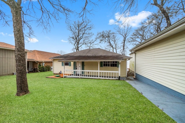 rear view of property featuring a yard and a porch