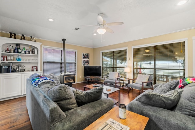 living room featuring dark wood-type flooring, ceiling fan, indoor bar, and crown molding