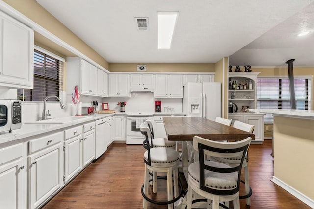 kitchen featuring dark hardwood / wood-style flooring, sink, white appliances, and white cabinets