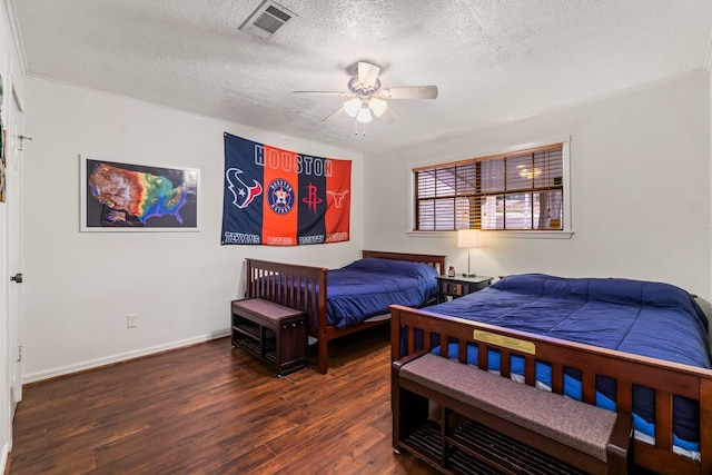 bedroom with ceiling fan, dark hardwood / wood-style floors, and a textured ceiling