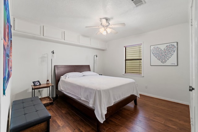 bedroom featuring ceiling fan, dark hardwood / wood-style flooring, and a textured ceiling