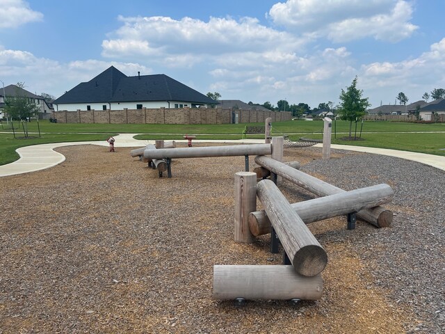 view of property's community featuring a residential view, a lawn, and fence