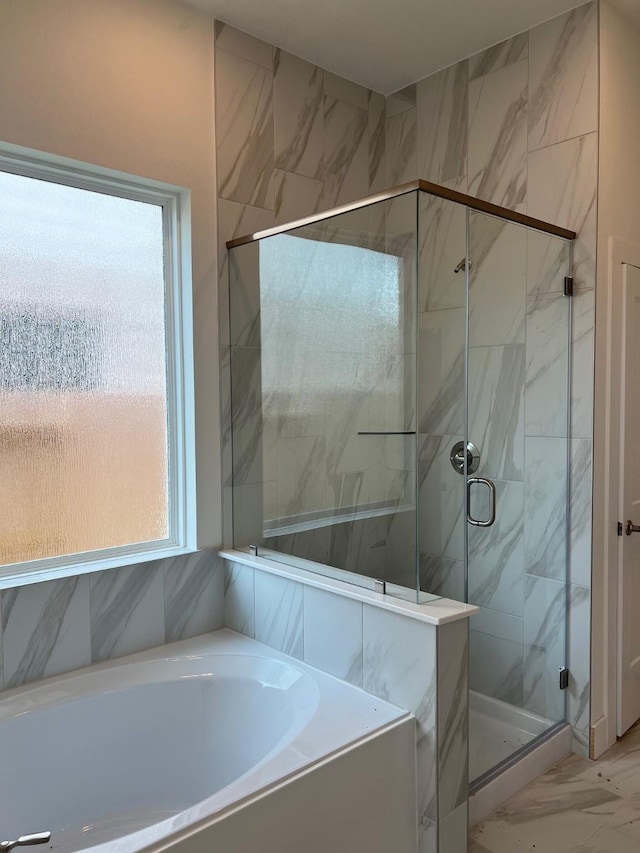 bathroom featuring a garden tub, marble finish floor, and a stall shower