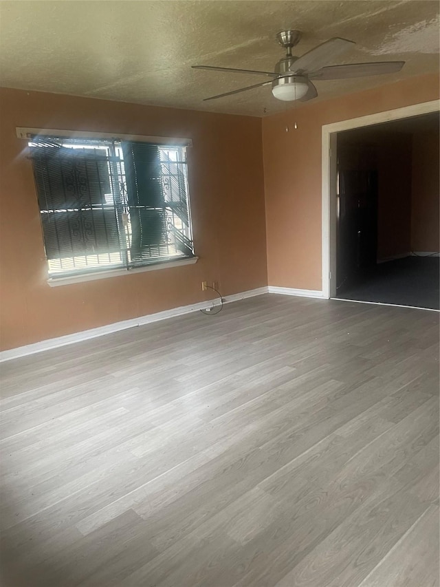 empty room with hardwood / wood-style floors, a textured ceiling, and ceiling fan