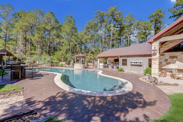 view of swimming pool featuring exterior bar and a patio