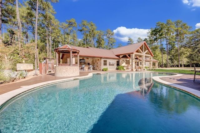 view of swimming pool featuring a patio area and a bar