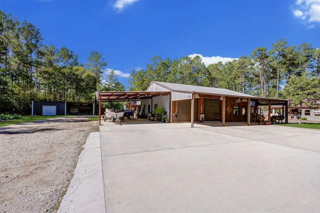 exterior space with a carport, a garage, and an outbuilding