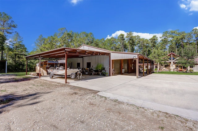 view of property exterior featuring a carport, a garage, and an outdoor structure