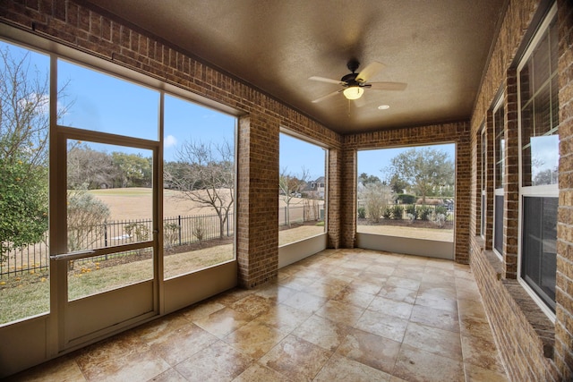 unfurnished sunroom with ceiling fan