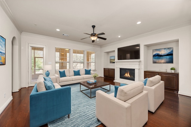 living room with crown molding, dark wood-type flooring, and ceiling fan