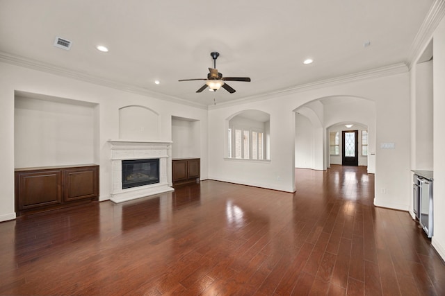 unfurnished living room with crown molding, dark hardwood / wood-style floors, and ceiling fan