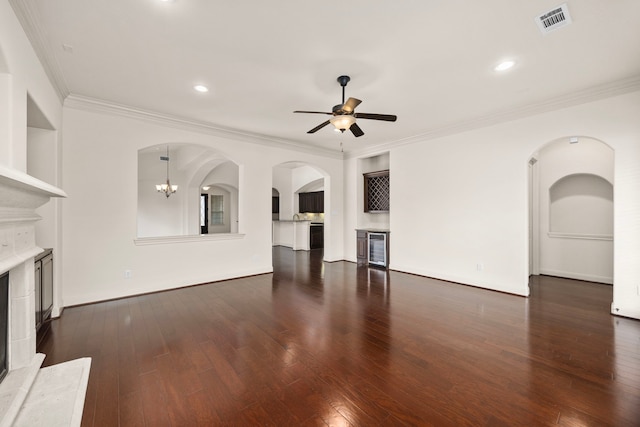 unfurnished living room featuring ornamental molding, beverage cooler, dark hardwood / wood-style floors, and ceiling fan with notable chandelier