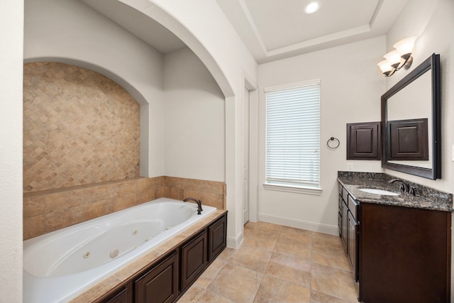 bathroom with vanity, a bathtub, and a raised ceiling