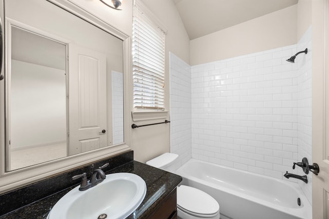 full bathroom featuring vanity, tiled shower / bath, and toilet