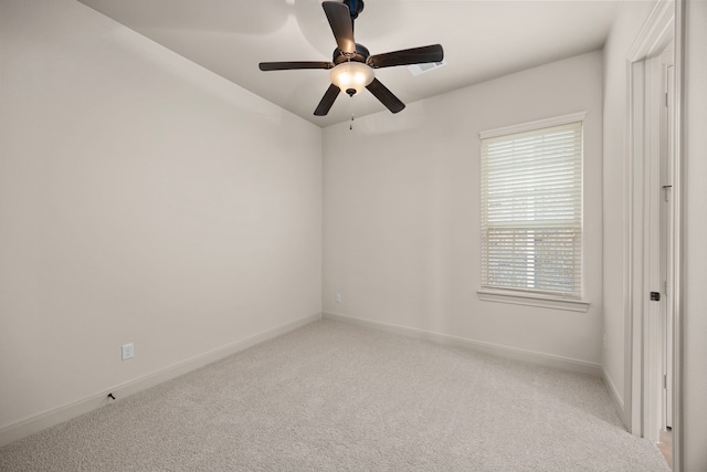 carpeted spare room featuring ceiling fan