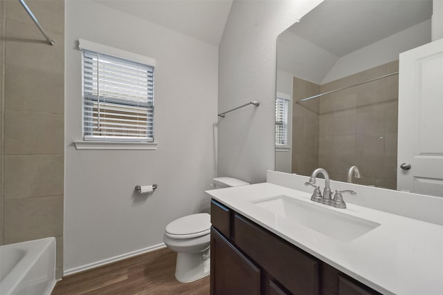 bathroom featuring vanity, hardwood / wood-style floors, vaulted ceiling, and toilet