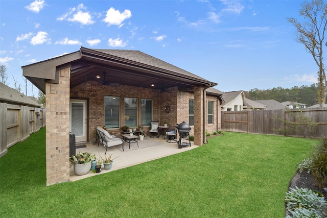 back of property with a lawn, ceiling fan, and a patio area