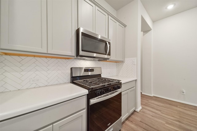 kitchen with tasteful backsplash, appliances with stainless steel finishes, and light hardwood / wood-style flooring