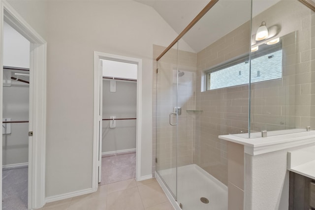 bathroom featuring tile patterned floors, a shower with shower door, vaulted ceiling, and vanity