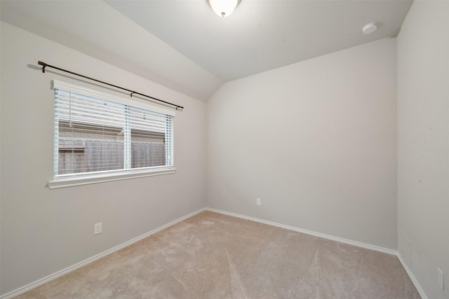 empty room featuring lofted ceiling and light colored carpet