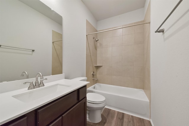 full bathroom featuring tiled shower / bath, vanity, toilet, and hardwood / wood-style floors