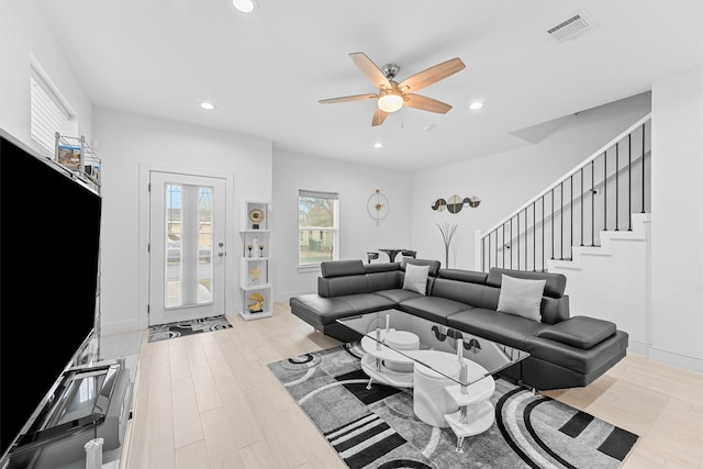 living room with ceiling fan and light wood-type flooring