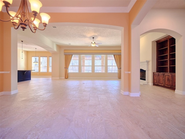 unfurnished living room with crown molding, ceiling fan with notable chandelier, a textured ceiling, and built in shelves