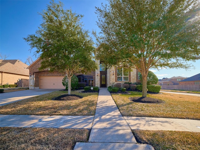 view of property hidden behind natural elements featuring a garage and a front yard