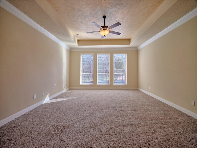 carpeted spare room featuring crown molding, ceiling fan, a tray ceiling, and a textured ceiling