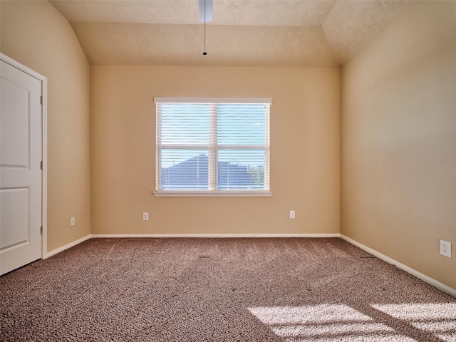 carpeted empty room with vaulted ceiling