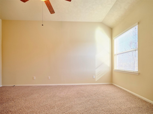 spare room featuring ceiling fan, lofted ceiling, carpet flooring, and a textured ceiling