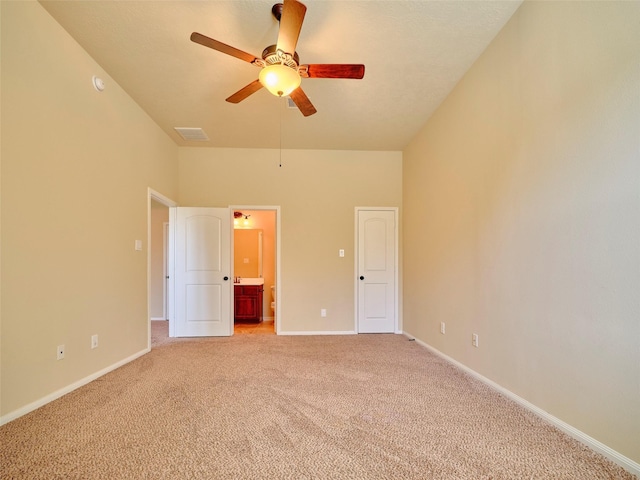 unfurnished bedroom featuring ceiling fan, ensuite bath, and light carpet